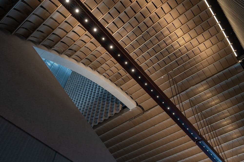 Recessed linear lighting set into a tiled ceiling